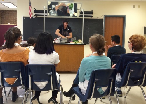 Chef demonstrates kneading the dough at the mirrored work station.