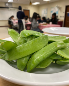 Sugar snap peas with students in the background