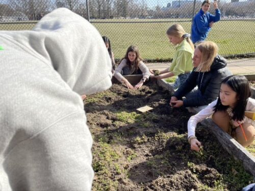 Master Gardener Debbie Gries at raised bed garden, and Faculty Advisor Betsey Valenza walking behind