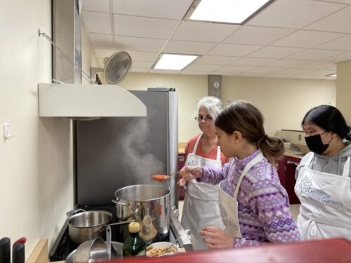 Adding ingredients to DIY soup in kitchen