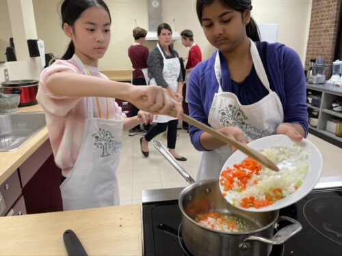 Students adding aromatics to the soup pot