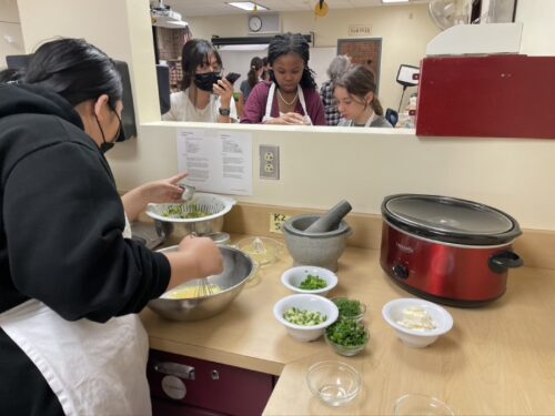 Students whisking eggs with other ingredients